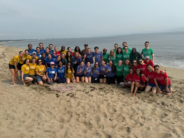 BCRP interns on the beach at their retreat in Maine with their chief family colored t-shirts