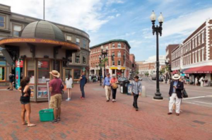 Harvard Square with people walking and buildings.